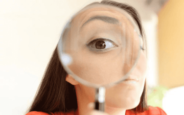 Woman looking through a magnifying glass 