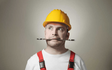 Man holds a wrench in his mouth 