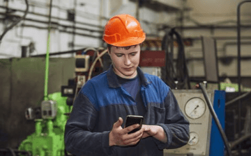 Maintenance worker looks over his task list in the field 