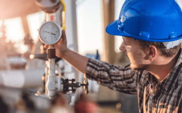 Maintenance worker checks gauge on equipment 