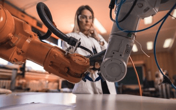 Woman looks on at robotic arm 