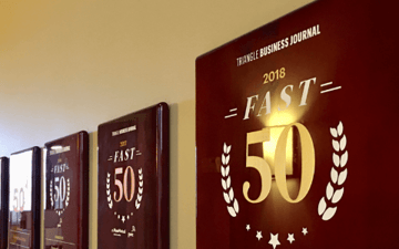 Multiple Fast 50 awards on a wall