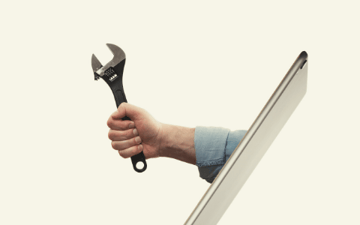 Hand holding a wrench coming out of a screen 