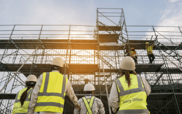 Maintenance workers look at scaffolding 